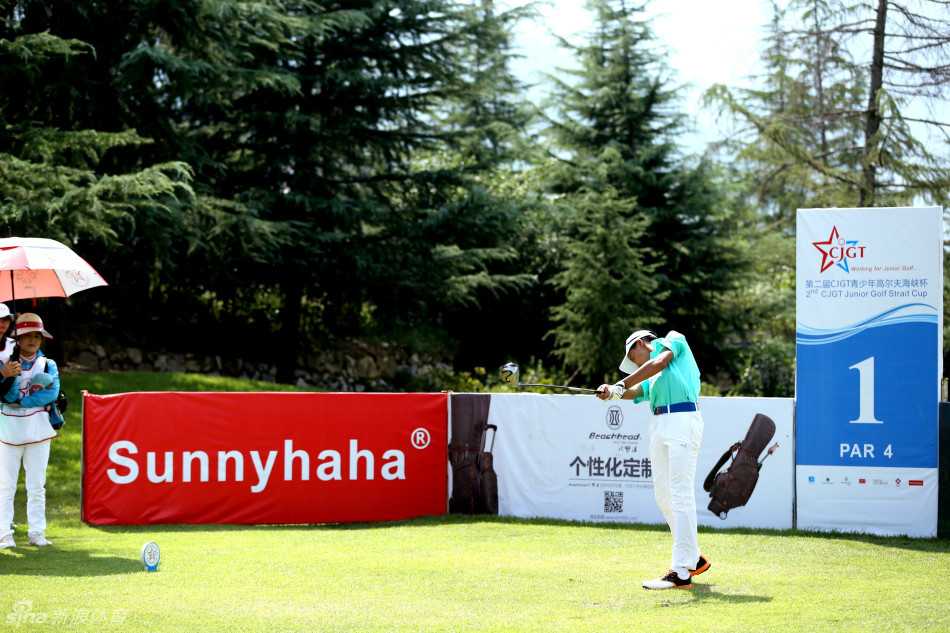 果岭上的友谊之战:海峡两岸高尔夫选手竞技交流纪实 两岸选手围成一圈亲切交谈,手势与笑容交织成友谊的桥梁,背景中的球道延伸向远方