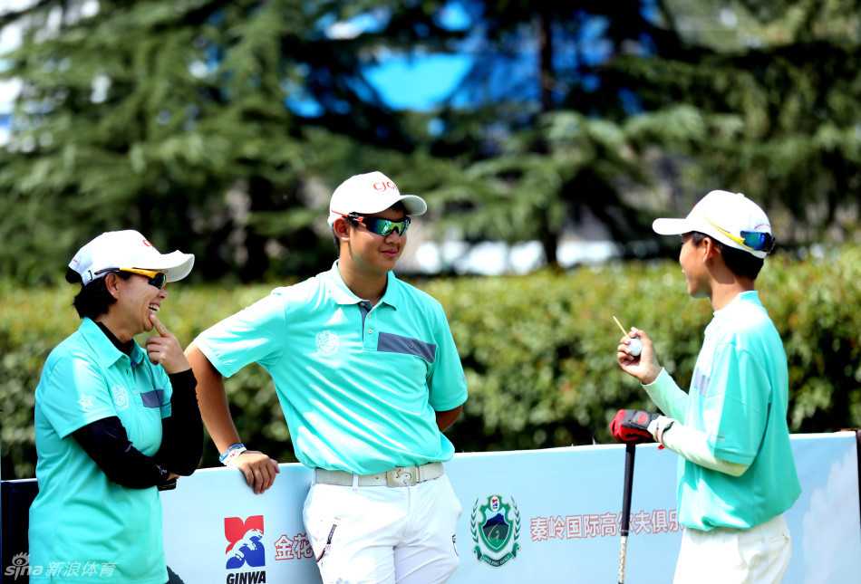 果岭上的友谊之战:海峡两岸高尔夫选手竞技交流纪实 球童与选手并肩而立,手指远方讨论战术,专业与信任在两人之间自然流动