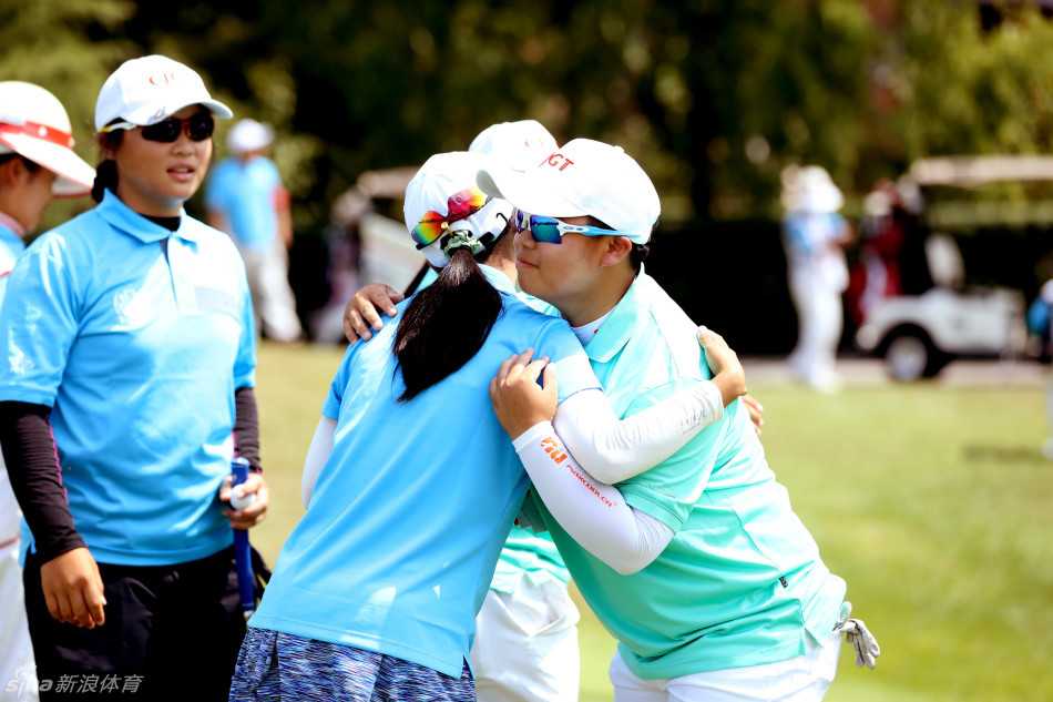 果岭上的友谊之战:海峡两岸高尔夫选手竞技交流纪实 两位选手在果岭旁热情相拥,笑容灿烂如阳光,竞技的紧张完全融化为兄弟般的情谊
