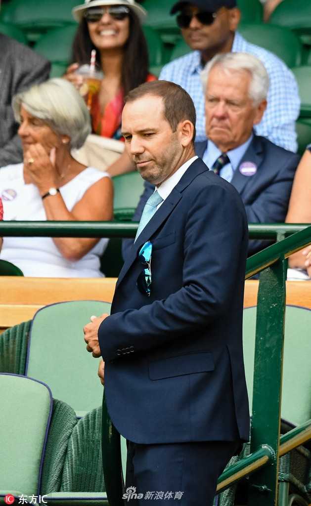 加西亚的丈夫手指赛场方向，似乎在向加西亚讲解比赛中的精彩瞬间