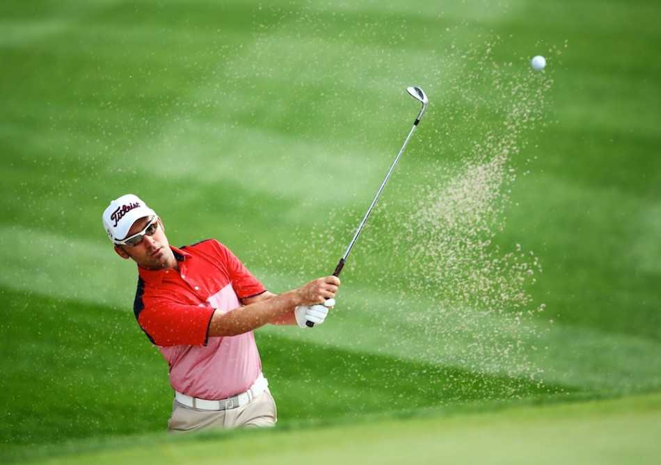 球员杰米·阿诺德悠然信步，穿过一座古朴的球场木桥，与背景中的绿茵和水景构成一幅和谐画卷。