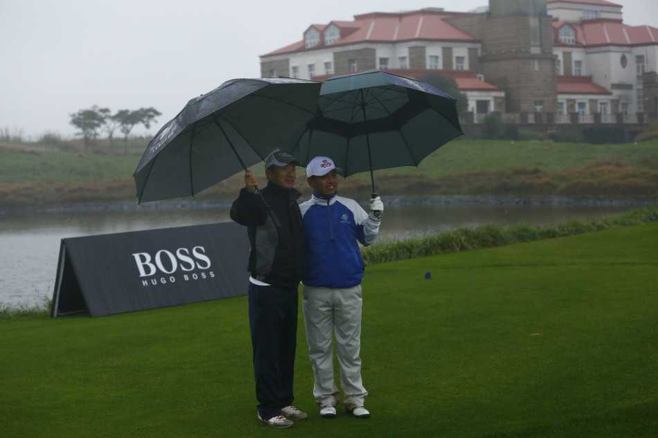 开球仪式上，嘉宾于伞下凝神聚力，白色小球即将破开雨幕飞向远方。