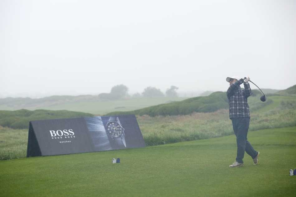 球员在雨中仔细观察球道，专注的眼神穿透雨帘，评估着下一杆的策略。