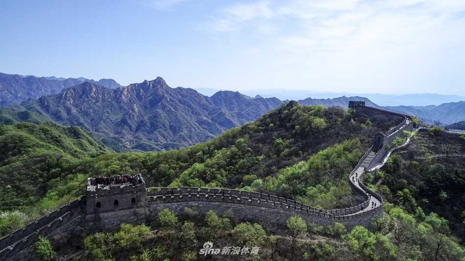 古琴师在铺着红色绸布的长城石台上专注抚琴，三位球星围坐静听，古老旋律与远处敌楼的剪影构成一幅跨越时空的画卷。