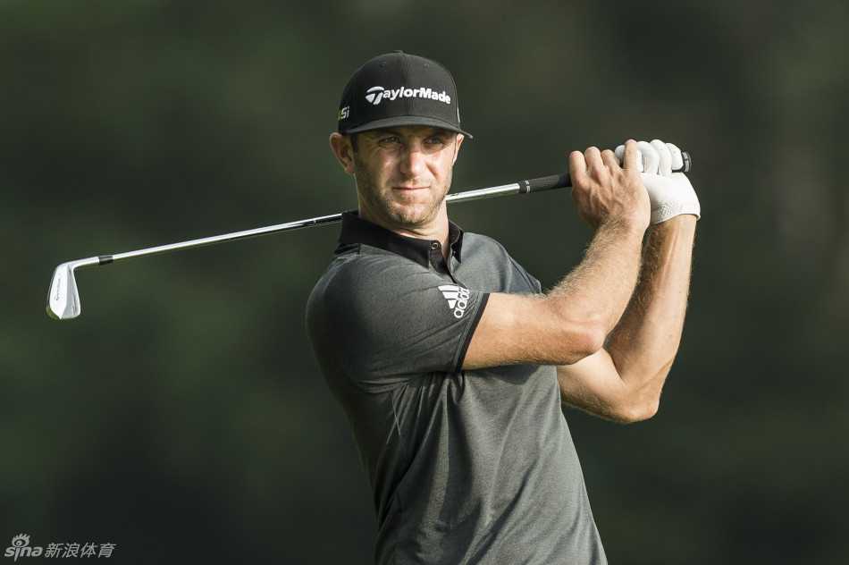 达斯汀-约翰逊侧身站立，神色凝重地观察果岭局势，手中球杆紧握，如临大敌。