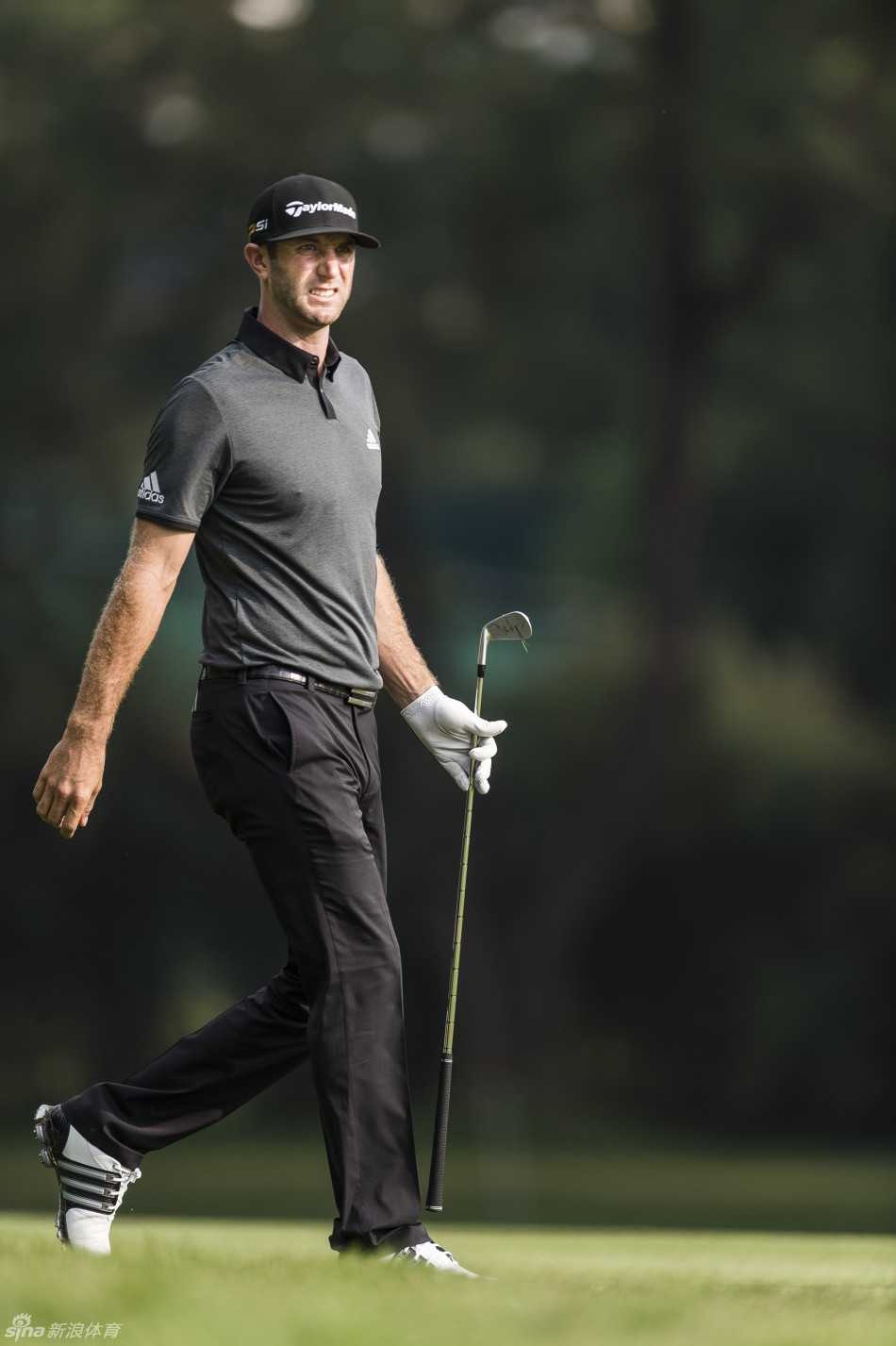 梁文冲在果岭边仔细观察推杆线路，眉头紧锁，陷入深思。