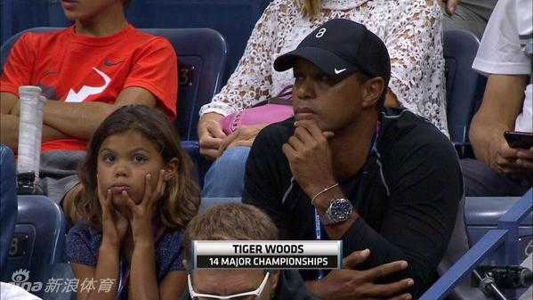 泰格·伍兹专注地凝视网球赛场，眼神锐利如昔，仿佛在分析着每一次击球的轨迹与策略。