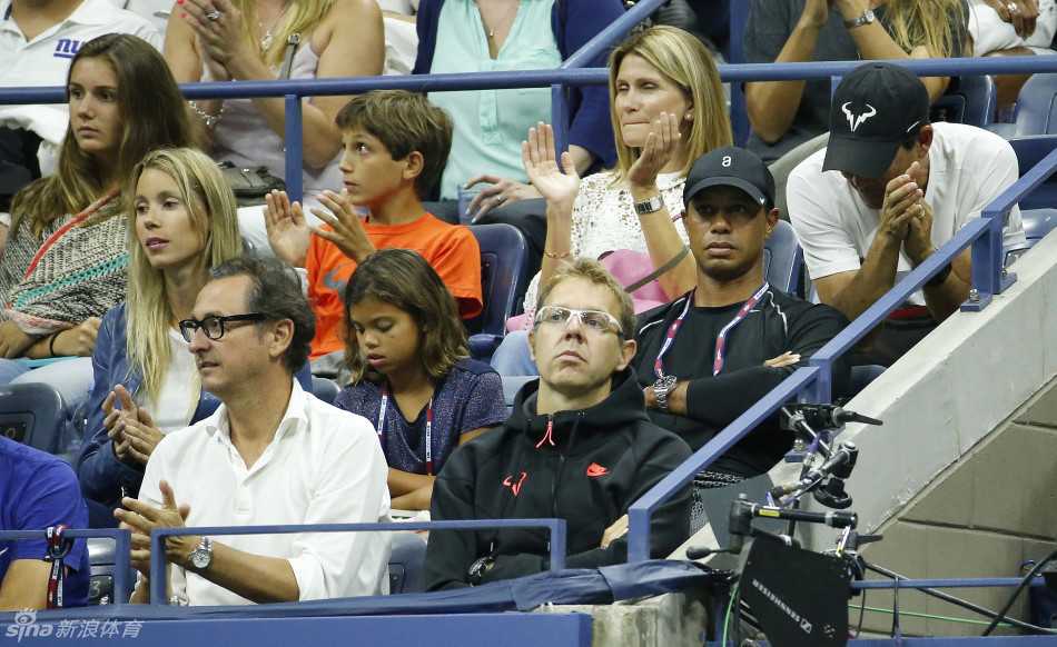 两位体坛传奇人物纳达尔与伍兹在赛场边亲切握手交谈，笑容真挚，象征着跨越运动疆界的友谊。