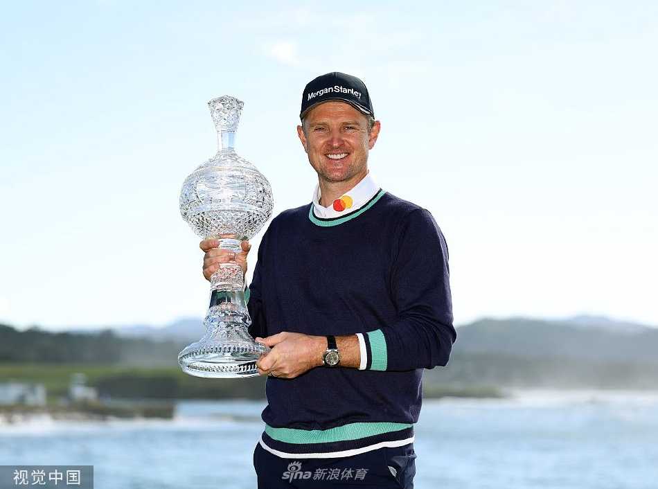 贾斯汀·罗斯面带温暖而释然的笑容，双手高高举起沉甸甸的水晶冠军奖杯，奖杯在阳光下熠熠生辉。