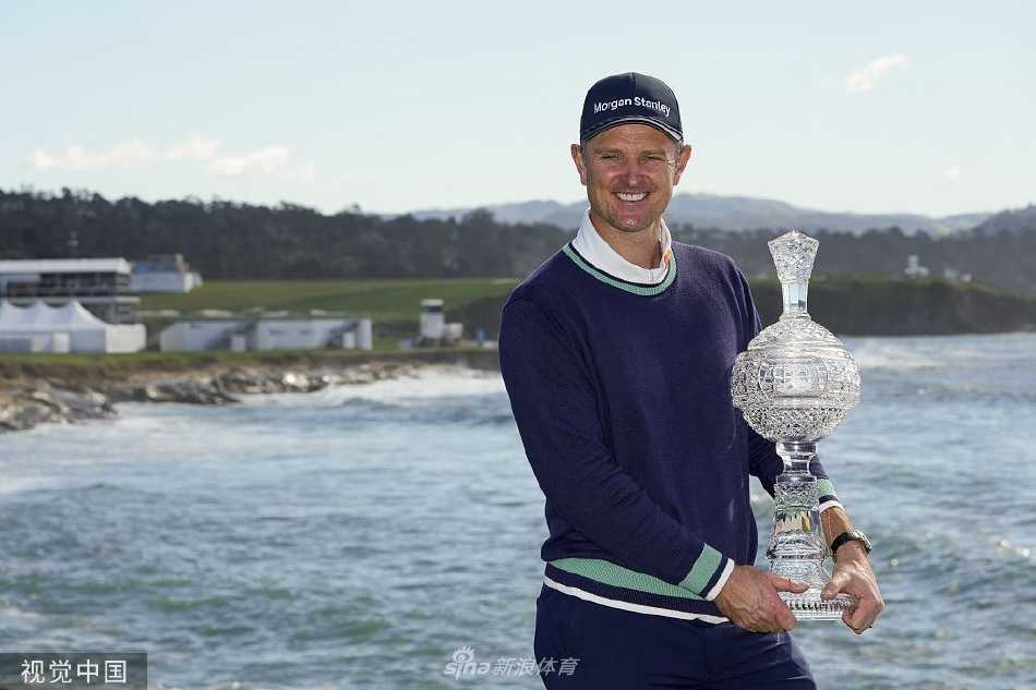 贾斯汀·罗斯在圆石滩第18洞果岭推入致胜一推后，紧握拳头，仰天发出胜利的呐喊，身后是波澜壮阔的太平洋。