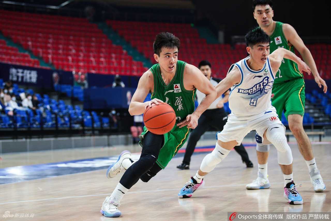 辽宁核心后卫赵继伟在宁波队外援特罗特的贴身紧逼下，神情坚毅地运球穿越中场，眼中闪烁着指挥官的冷静与锐利。