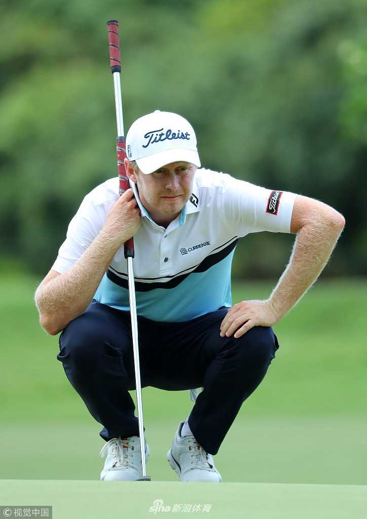 库尔特·北山在毛里求斯公开赛决赛轮中，全神贯注地审视果岭推杆线路，眼神坚定而沉着。