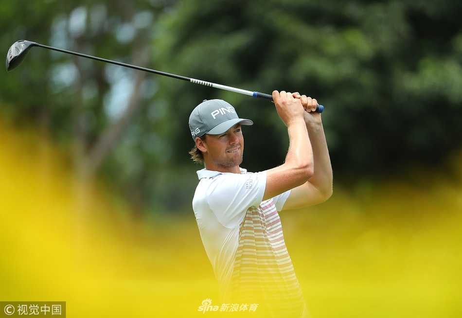 北山在练习轮中与球童交流，毛里求斯四季球场湛蓝的水障与修剪整齐的球道构成一幅优美画卷。