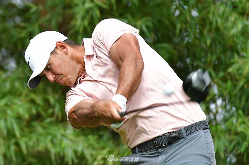 基根·布拉德利在果岭上屏息推杆，阳光洒下勾勒出专注的侧影