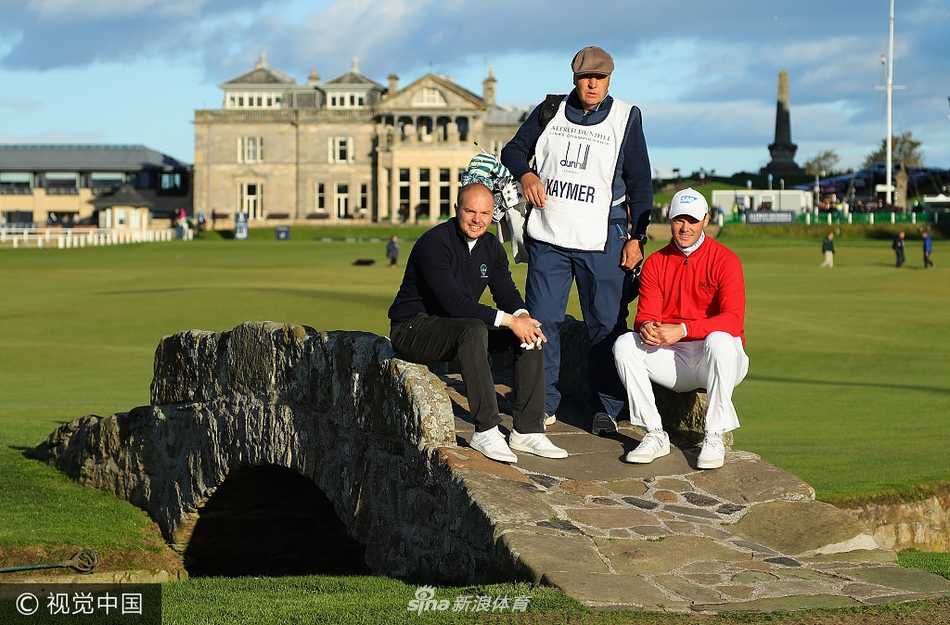 麦克罗伊在练习果岭上专注地进行推杆练习，身后是历史悠久的老球场会所。