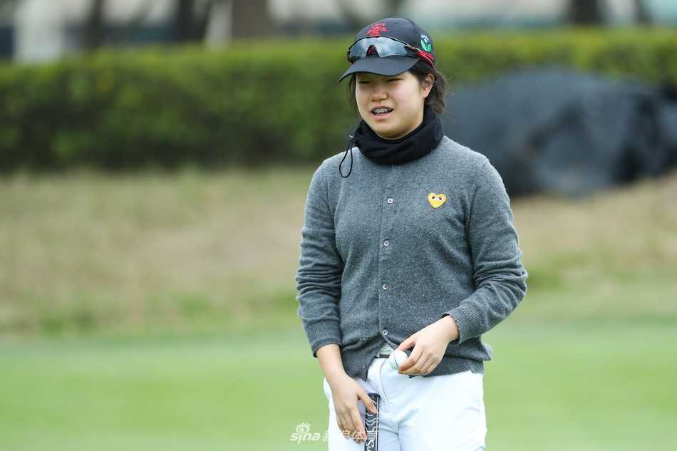 赛场之上年轻球员全神贯注挥杆击球，白色小球在冬日晴空下划出优美弧线