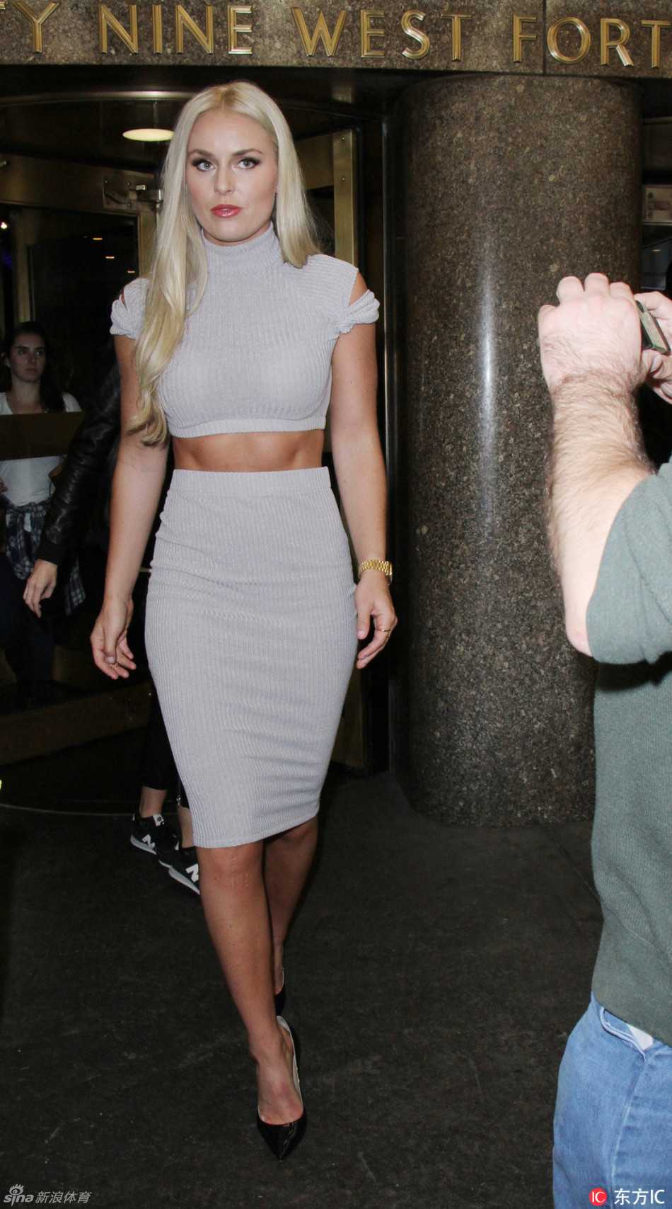 林赛·沃恩在纽约书展上绽放自信笑容，手臂线条清晰，展现运动员的力与美。