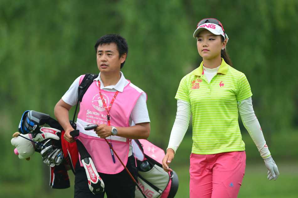 石昱婷果岭推杆，目光如静湖锁住球洞，指尖微力酝酿决胜一击