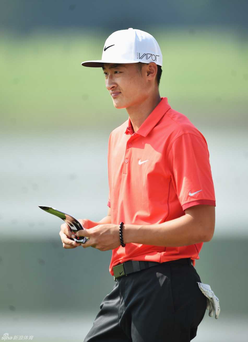 中国高尔夫新星李昊桐在比赛中全神贯注，手握短铁杆仔细测算着攻击果岭的距离与弹道。