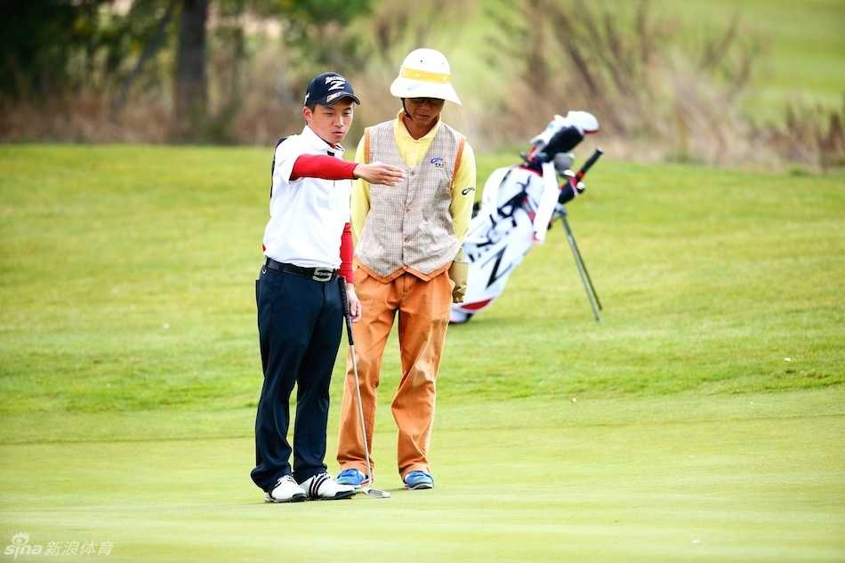 球员金智洋正从沙坑中将球救出，沙粒飞扬间展现力量与技巧