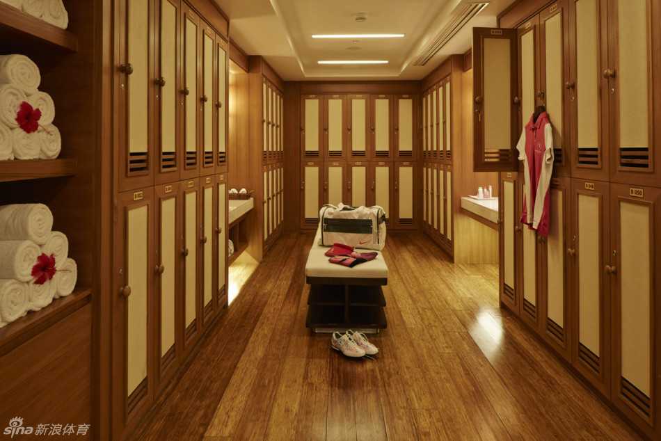 夕阳下的练习场美景，打位向着无尽的绿茵延伸，天空被染成橙红色，投下长长的金色光影。