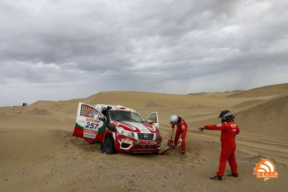 赛车在广阔的雅丹地貌中飞驰，雄伟的自然造物与人类工业结晶同框，构成一幅充满视觉冲击力的壮丽画卷。