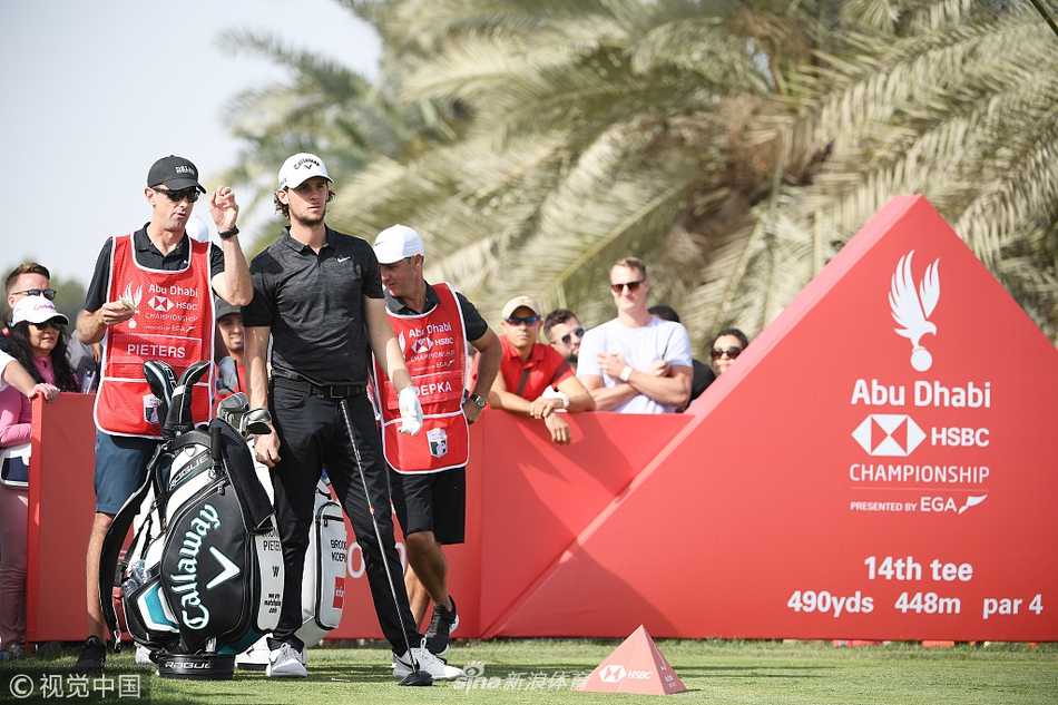 沙漠绿洲上的王者对决,劳瑞三杆领先剑指阿布扎比桂冠 肖恩·劳瑞在阿布扎比球场第18洞果岭上凝神观察推杆线路,背景中独具特色的猎鹰造型会馆在阳光下熠熠生辉。