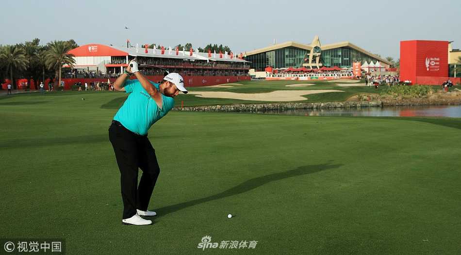 阿布扎比锦标赛决赛轮，观众聚集在果岭周边，屏息凝神观看球员推击，现场充满了大赛的紧张与热烈气氛。