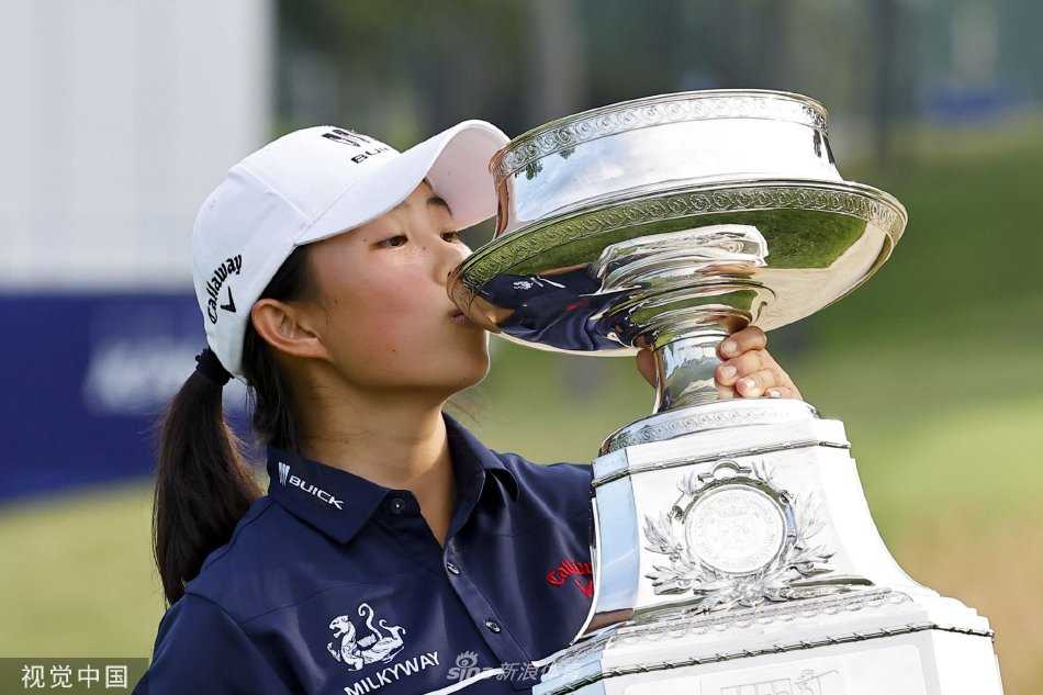 在第十八洞果岭向观众致意，身后是夕阳镀金的恢弘球场