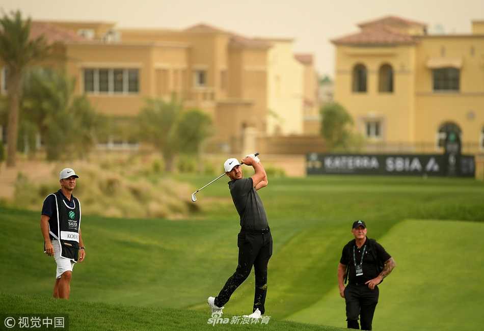 德尚博在练习场全力挥杆，展示其标志性的力量型打法，球杆在空气中划出凌厉轨迹。