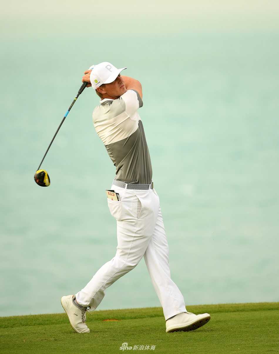 一位球星在练习轮中专注地进行切杆练习，背景是湛蓝的天空与独特的赛场建筑。