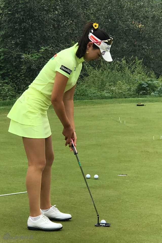 绿茵之上群星闪耀记中国高尔夫球手们的训练与传承 两位青少年高尔夫学员正在果岭上互相交流推杆技巧,分享心得