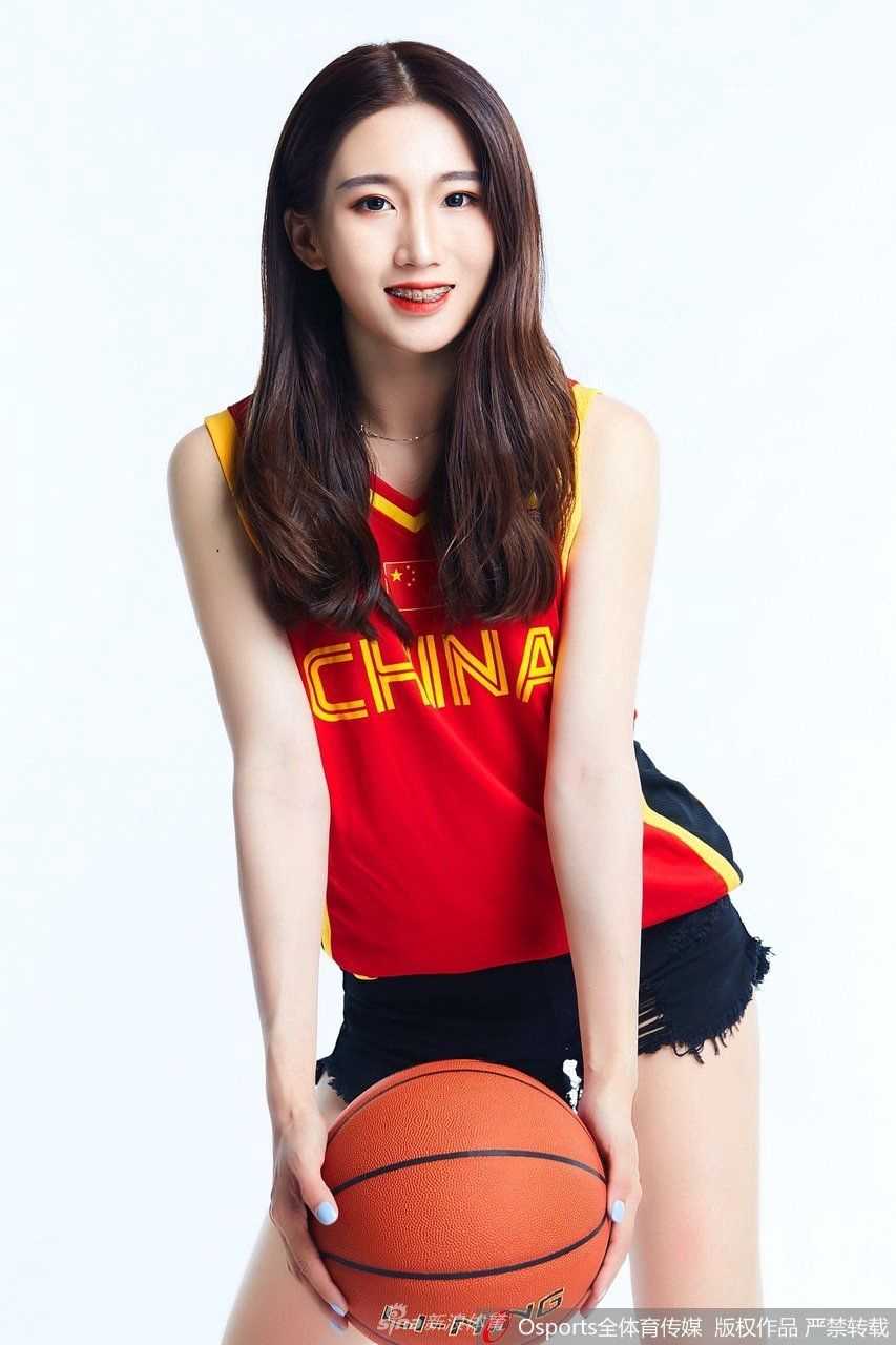 篮球宝贝侧身凝视，优雅的线条与专注的神情传递出赛场之外的静谧之美，与球场的热烈形成动人对比