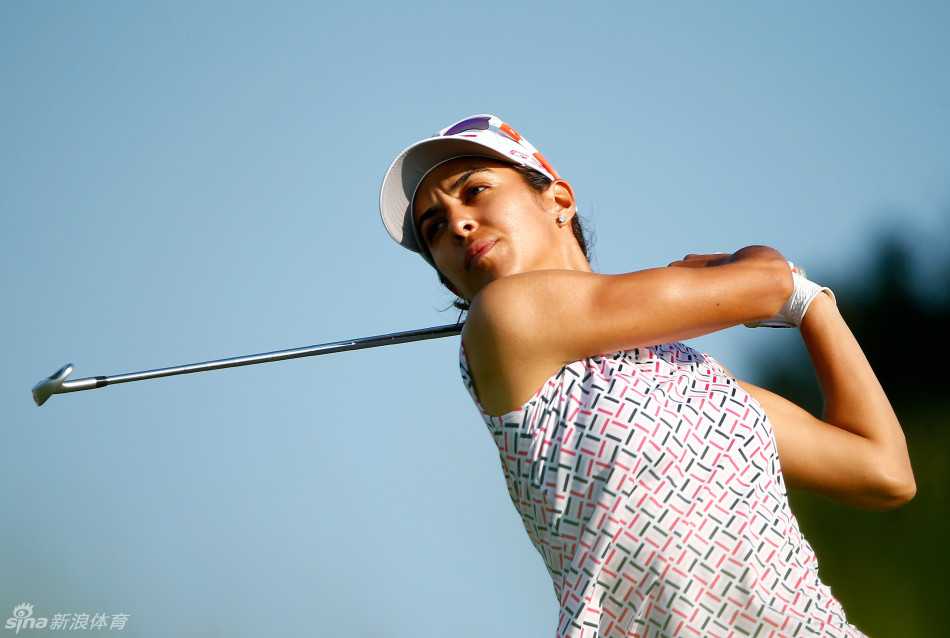 宝拉-瑞托观察果岭坡度神情专注，手中的推杆与脚下的绿茵同样引人注目。