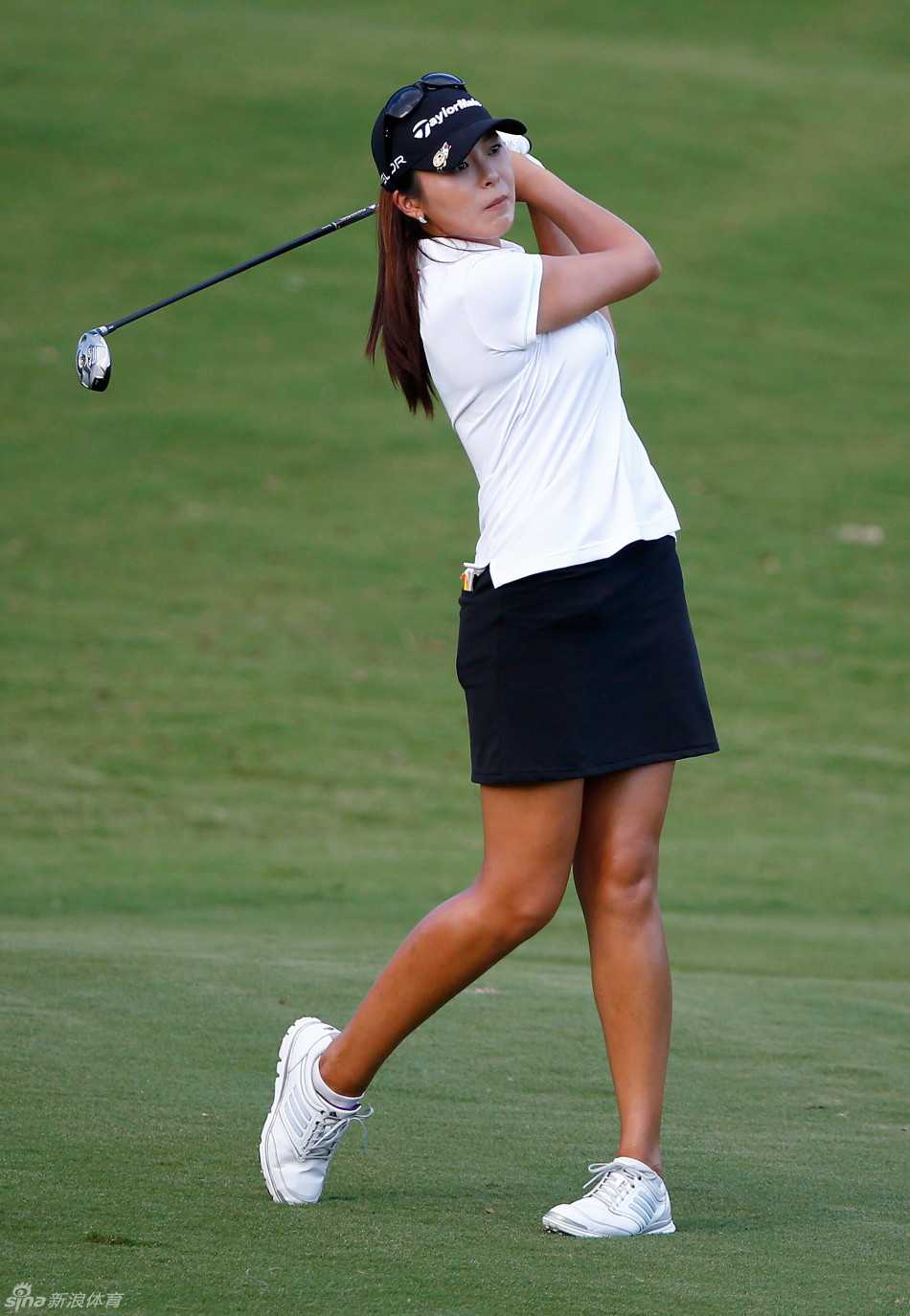 杰伊-玛丽-格林在发球台从容准备，整个球场的壮丽画卷在她身后展开。