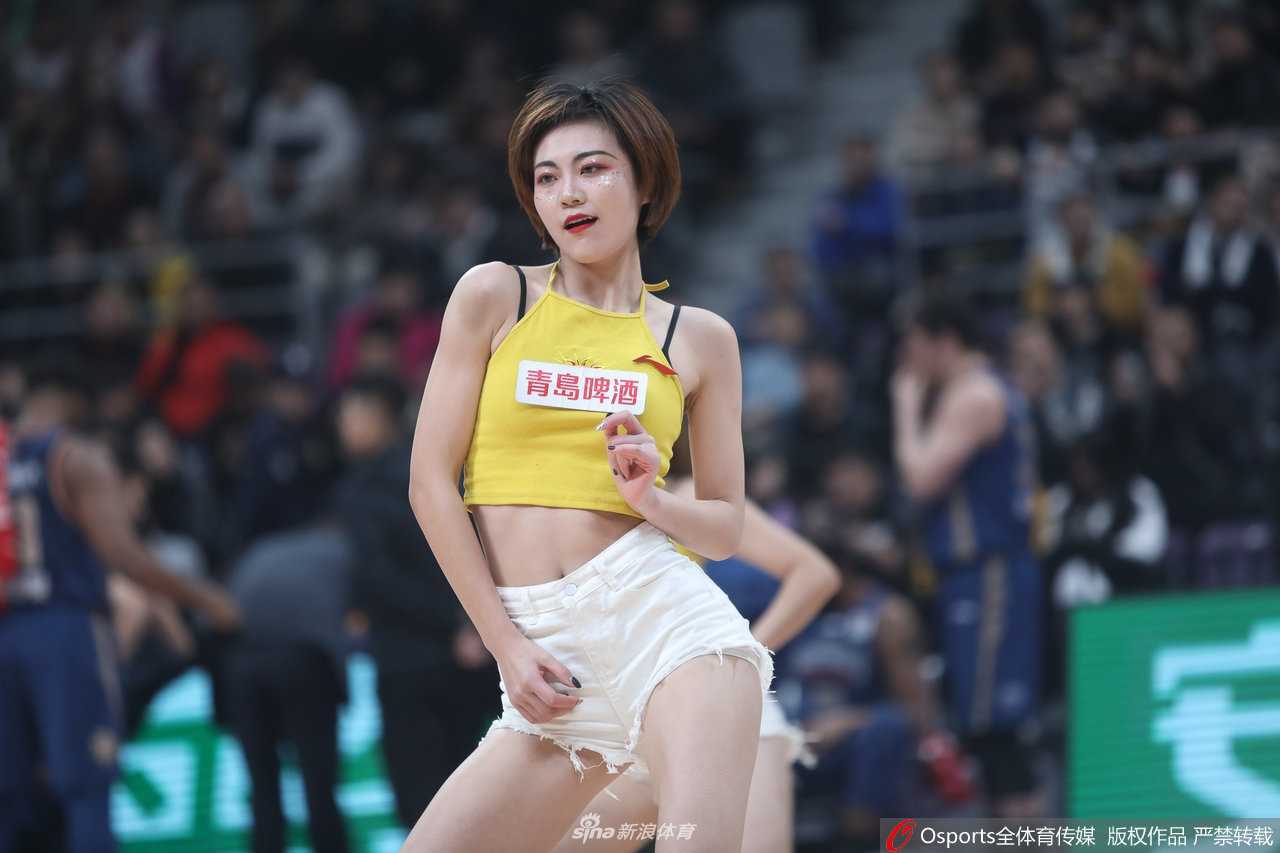 总决赛现场全景，场上是球员们奋力拼抢，场边是辽宁啦啦队整齐划一的动作，姑娘们与身后举着助威牌的观众融为一体，气氛热烈