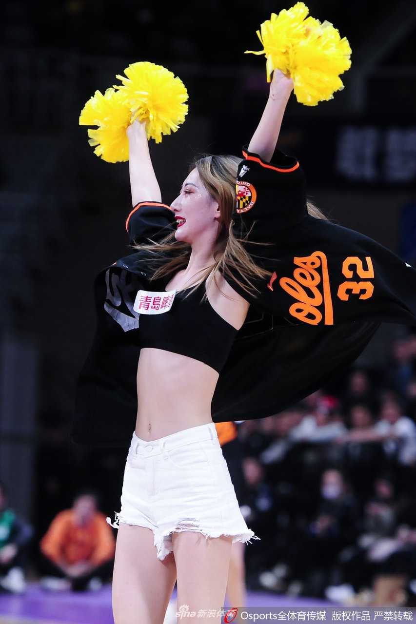 辽宁啦啦队队员身着黑白相间的活力装束，扎着清爽的高马尾，眼神专注而明亮，在暂停时刻为场上球员加油鼓劲