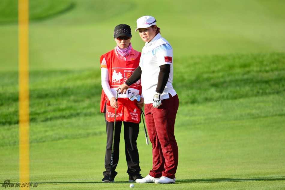 潘艳红与卢月霞在果岭旁默契商讨攻果岭策略，展现团队合作精神