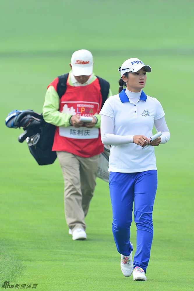 老将陈利庆独自行走在开阔球道上，从容步态中透露出丰富的比赛经验