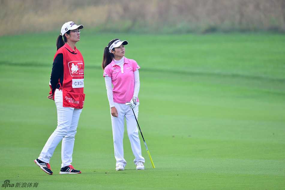 陈翠霞与球童张健并肩前行于球场，在行进中密切交流下一杆策略