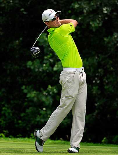 扎克·约翰逊与球童达蒙·格林在赛道上紧密合作，专注地讨论着下一杆的策略，两人的默契是赛场上最坚实的后盾。