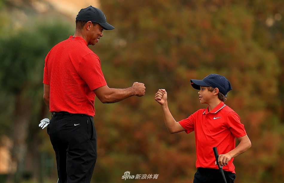 决赛轮开球前，泰格与查理身着经典的周日红衫黑裤，神情专注地进行最后交流，父子间的默契无需多言