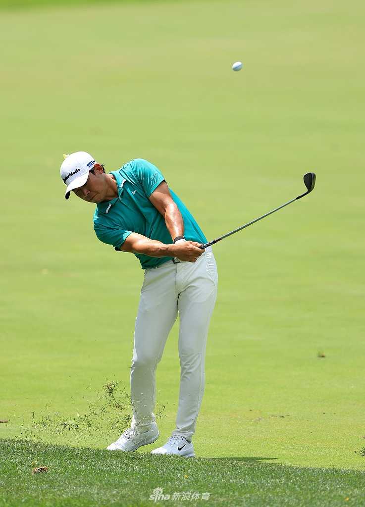 张新军在球道上稳健挥杆，阳光勾勒出流畅的挥杆动作与坚定的身形。