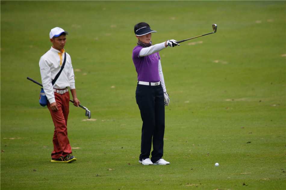 三位裁判员在绿茵场上并肩而立，进行赛前最后的交流，他们手持计时器与口哨，背影显得专业而可靠。