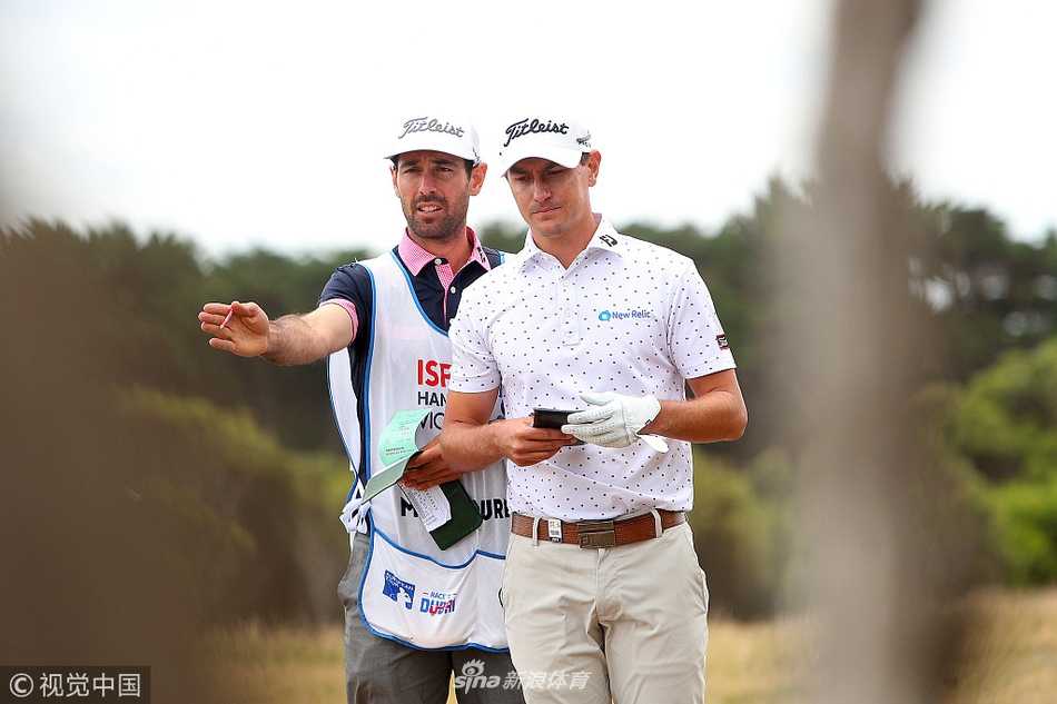 兰利轻松走向下一洞，与球童交流面露微笑