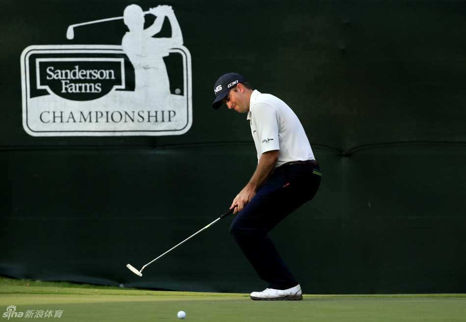 汤姆·霍吉在果岭边精细切球，身体姿态放松而专注，眼神充满计算