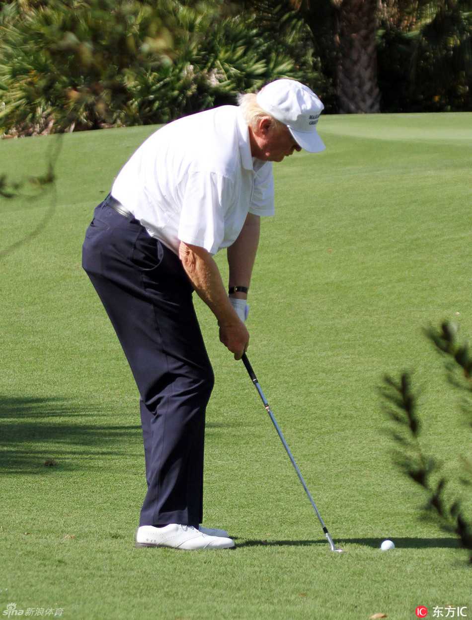 特朗普正全神贯注地做出标准的上杆动作，球杆挥至顶点，姿态充满力量感