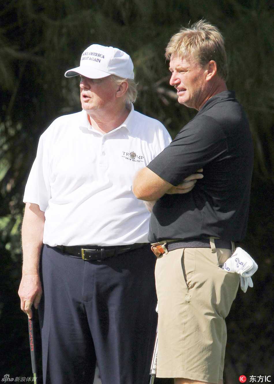 特朗普与南非著名高尔夫球星厄尼·埃尔斯在果岭附近交流，两人面带微笑，气氛融洽