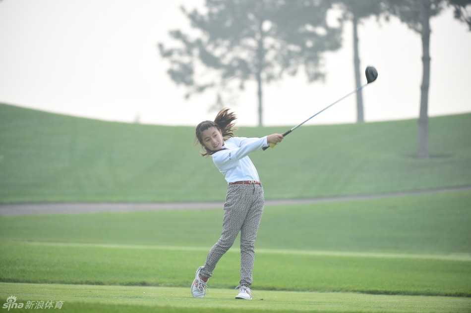 小球手在沙坑中全神贯注救球，飞扬的沙粒映照着他坚定的侧脸