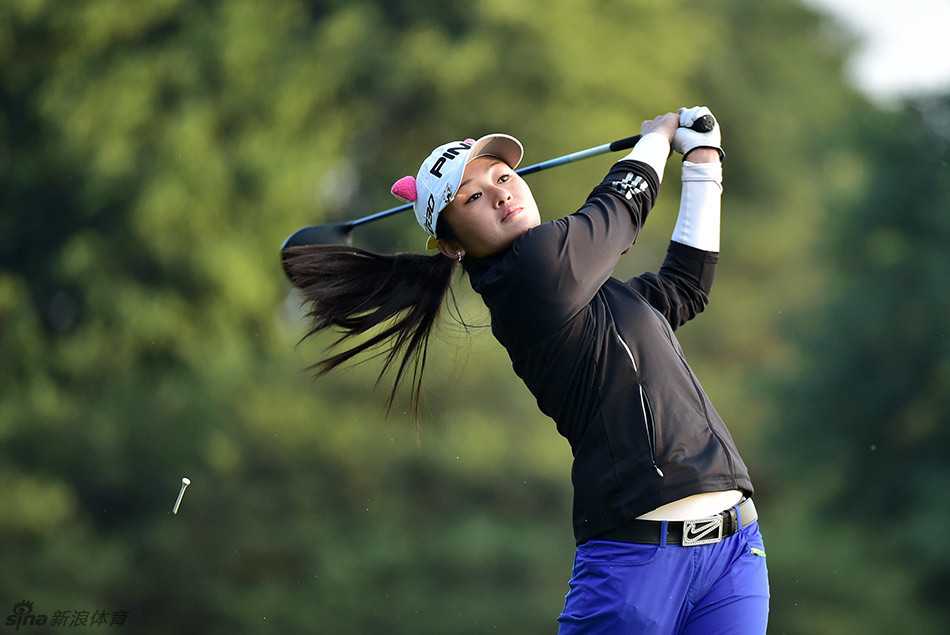 金孝周全神贯注地蹲在果岭边，目光如炬，仔细研判高尔夫球滚动的每一寸线路。